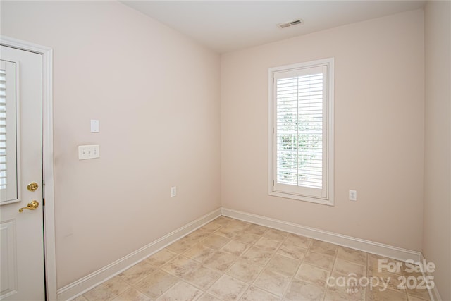 unfurnished room featuring visible vents and baseboards