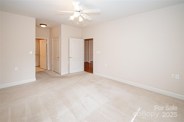 unfurnished room featuring ceiling fan, baseboards, and light colored carpet