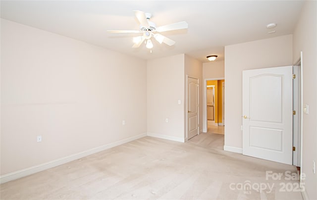 unfurnished room featuring baseboards, a ceiling fan, and light colored carpet