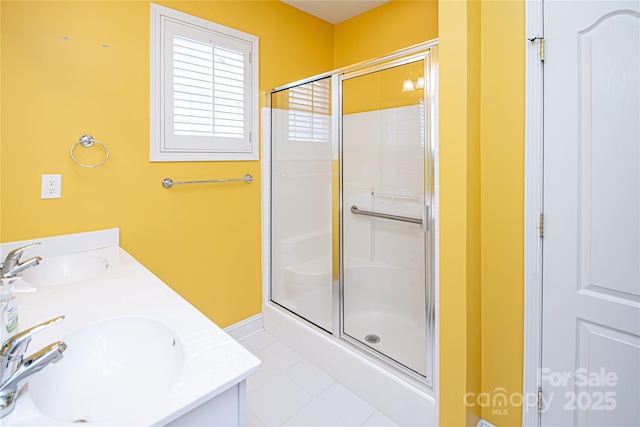 full bath featuring double vanity, tile patterned flooring, a shower stall, and a sink