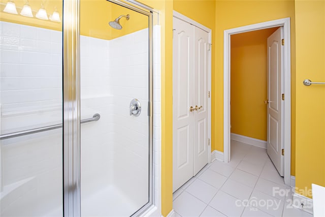 full bathroom featuring a stall shower, tile patterned flooring, and baseboards