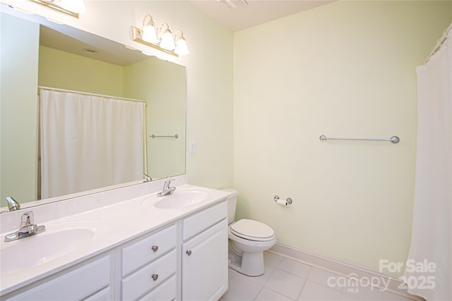 full bath featuring toilet, double vanity, a sink, and tile patterned floors