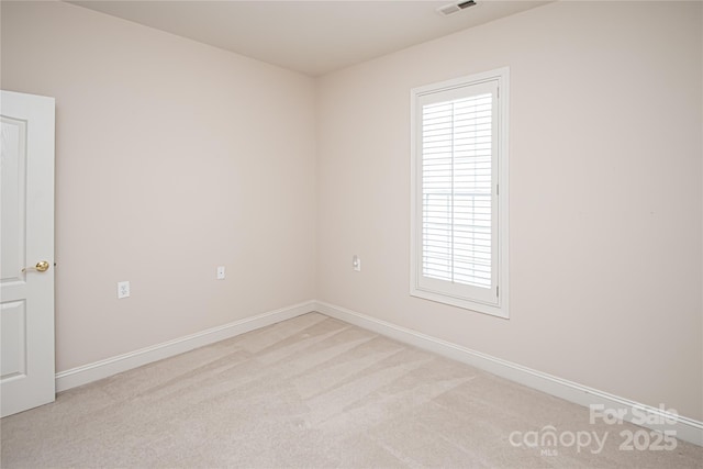 unfurnished room with baseboards, visible vents, and light colored carpet