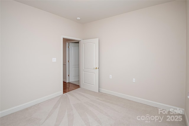 unfurnished room with baseboards and carpet flooring