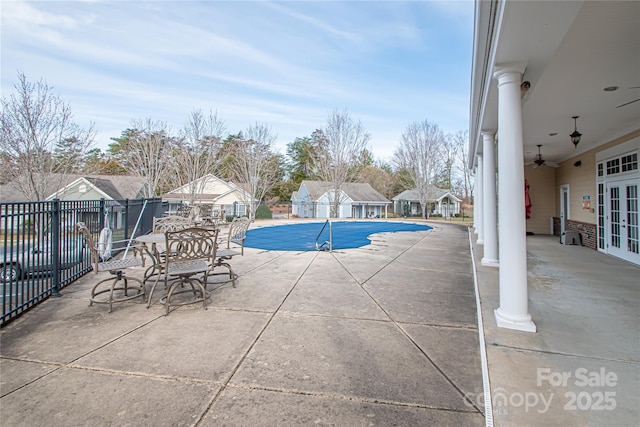 community pool featuring ceiling fan, fence, a patio, and french doors