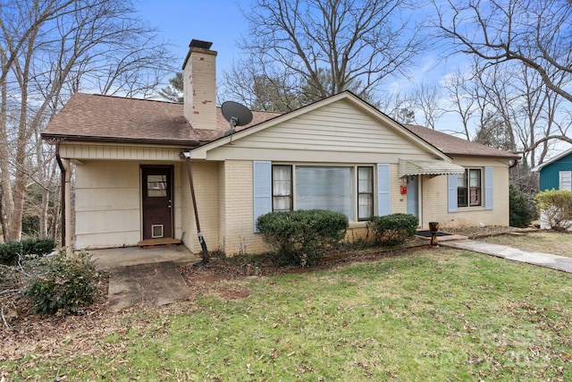 ranch-style house featuring brick siding, a front lawn, a chimney, and a shingled roof