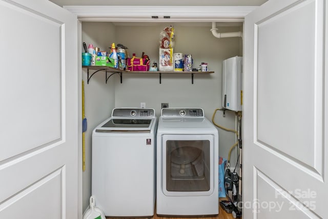 clothes washing area with laundry area, washing machine and dryer, and water heater