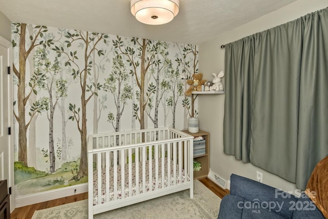 bedroom featuring wood finished floors, visible vents, and baseboards