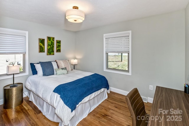 bedroom featuring baseboards and wood finished floors