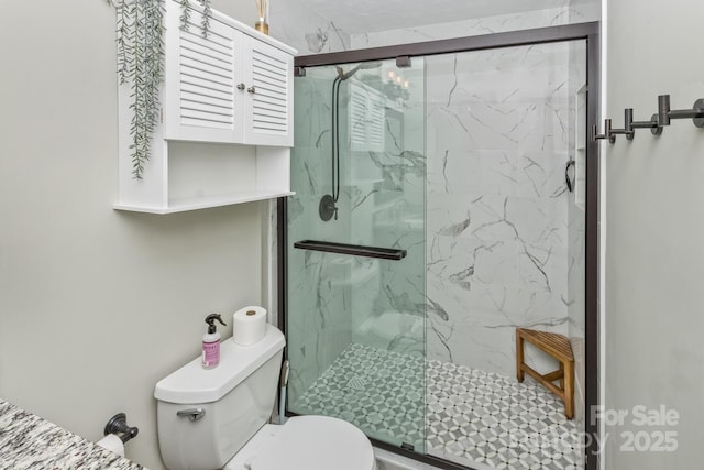 bathroom featuring toilet and a marble finish shower