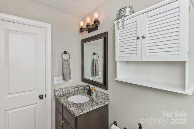 bathroom with a textured ceiling and vanity