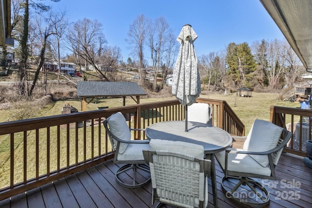 wooden deck featuring a gazebo, outdoor dining area, a lawn, and central air condition unit