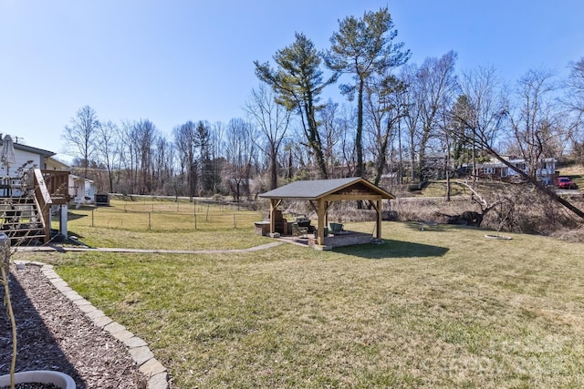 view of yard with fence, a deck, a gazebo, and stairs