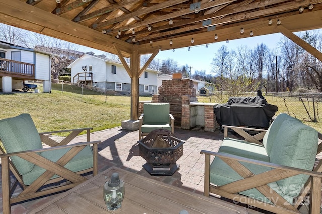 view of patio / terrace featuring a fire pit, an outdoor brick fireplace, and fence