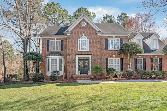 view of front facade featuring a front yard, french doors, and brick siding