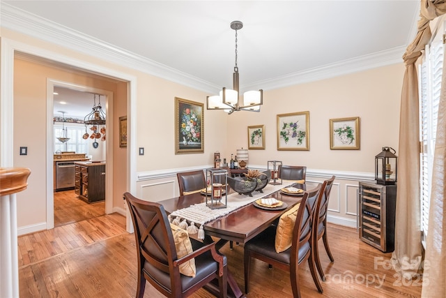 5101 Belicourt Dr, Charlotte, NC 28277 - dining space with ornamental molding, wine cooler, light wood-style flooring, and an inviting chandelier