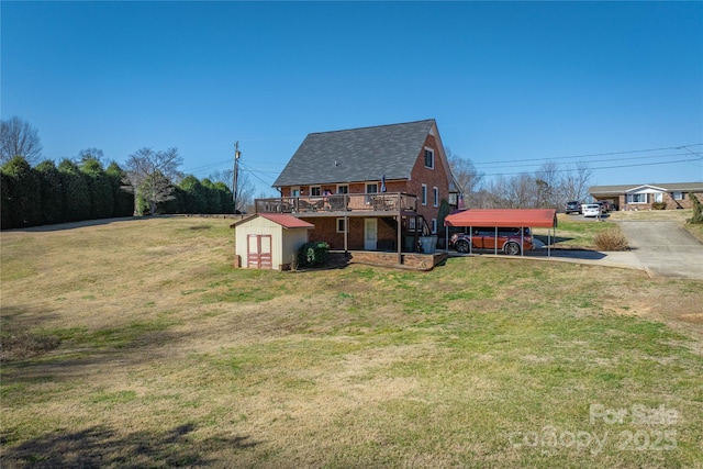 back of house featuring an outbuilding, brick siding, a lawn, a storage shed, and a wooden deck