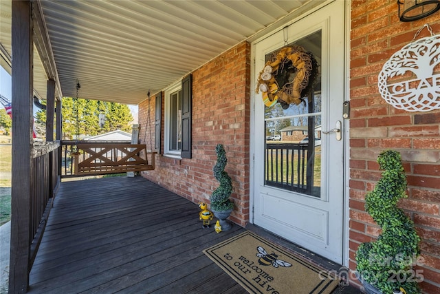 exterior space with covered porch and brick siding