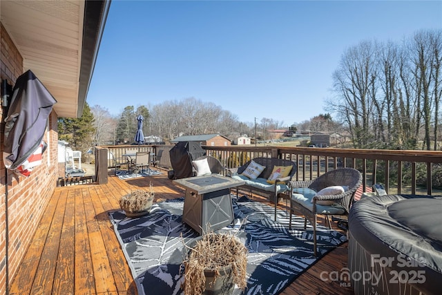 wooden deck with outdoor dining area, an outdoor living space with a fire pit, and a hot tub