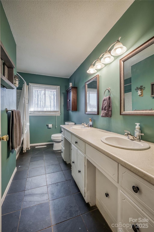 full bathroom featuring double vanity, toilet, a shower with curtain, a textured ceiling, and a sink