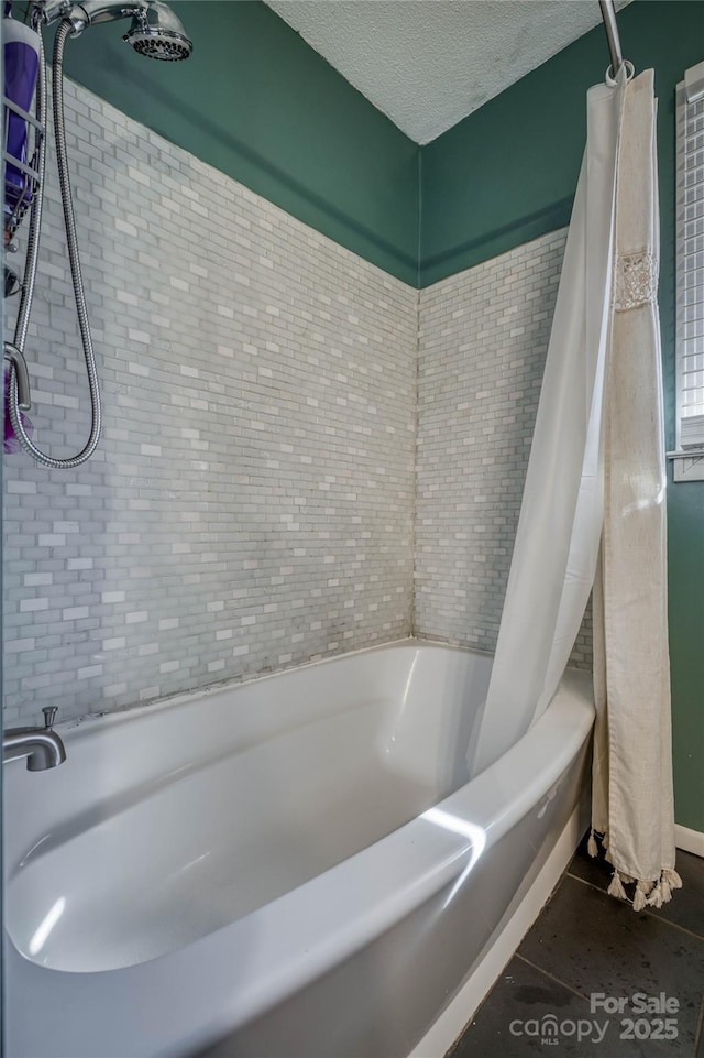 full bath featuring a textured ceiling and shower / tub combo with curtain