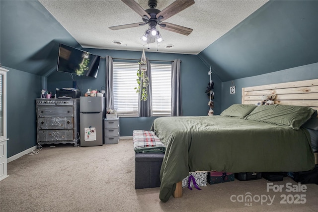 bedroom featuring baseboards, a textured ceiling, and freestanding refrigerator