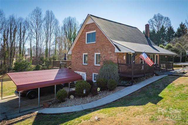 view of side of property featuring brick siding, a yard, a chimney, and a wooden deck