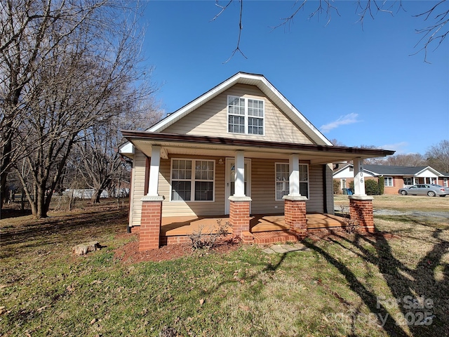 view of front of home with covered porch and a front yard