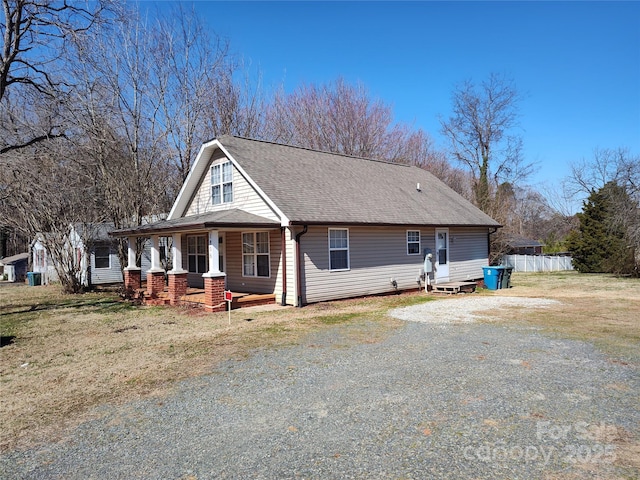 1806 Bringle Ferry Rd, Salisbury, NC 28146 - view of front of house with a porch, a front yard, roof with shingles, and driveway