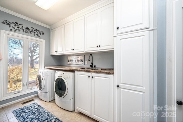 laundry room with crown molding, cabinet space, visible vents, a sink, and separate washer and dryer