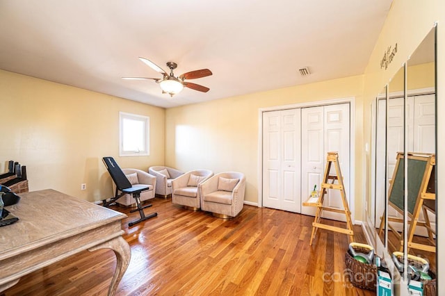 office featuring light wood-type flooring, ceiling fan, and visible vents