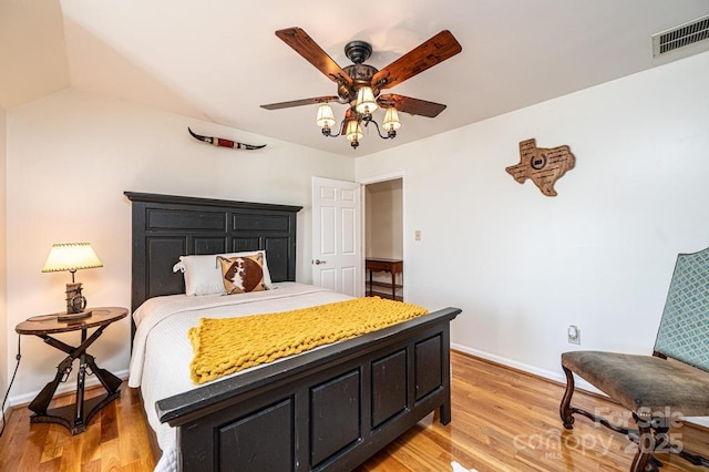 bedroom featuring light wood finished floors, baseboards, visible vents, and ceiling fan