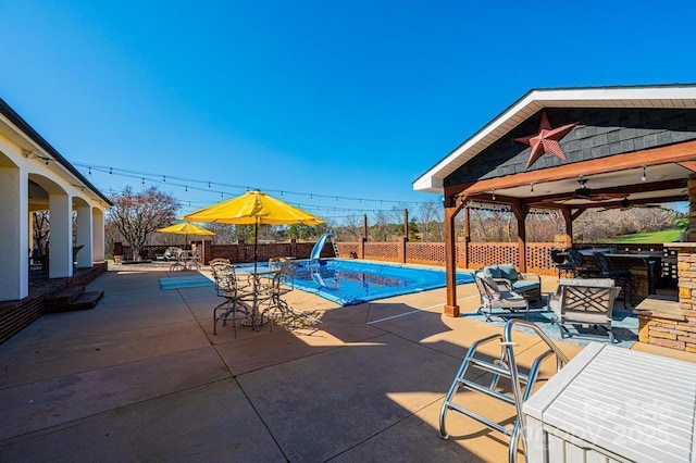 view of pool featuring a fenced in pool, outdoor dry bar, a patio area, a water slide, and a fenced backyard