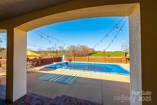 view of pool featuring a patio area, a fenced backyard, a fenced in pool, and a water slide