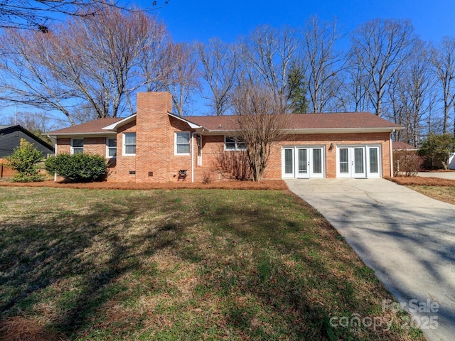 ranch-style house featuring brick siding, a chimney, crawl space, french doors, and a front yard