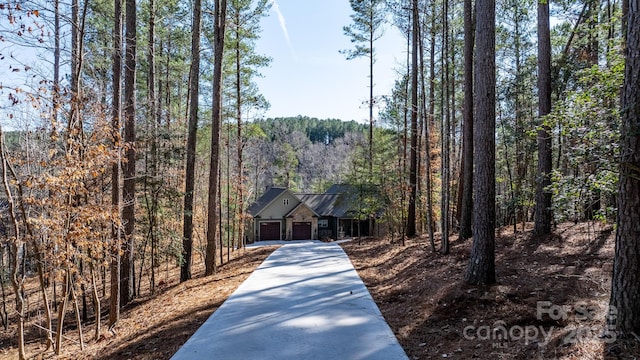 view of front of property with a garage and a forest view