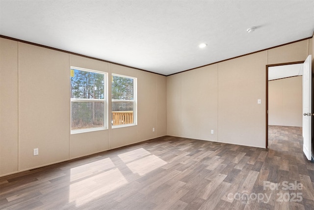 spare room featuring crown molding and wood finished floors