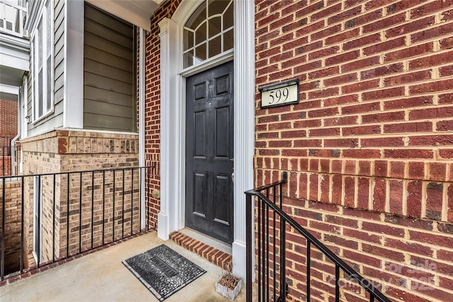 view of exterior entry featuring brick siding