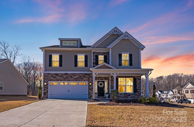 view of front of property featuring a garage, concrete driveway, a front lawn, and stone siding