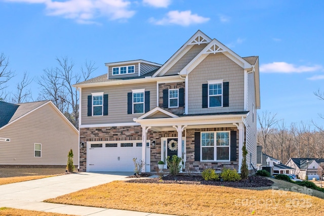 craftsman-style house featuring concrete driveway, covered porch, a front yard, a garage, and stone siding