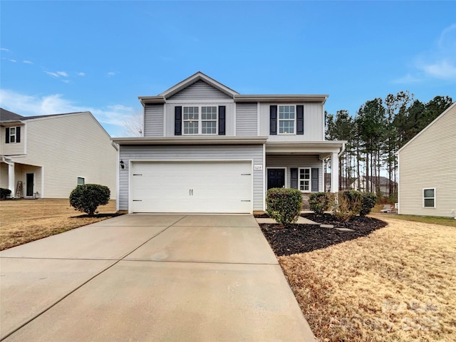 traditional-style home with a garage, concrete driveway, and a front lawn