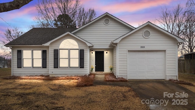 ranch-style house featuring concrete driveway, a shingled roof, and an attached garage