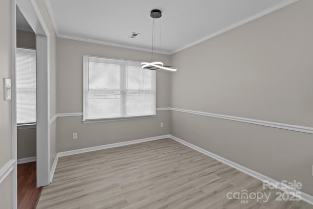 unfurnished dining area featuring ornamental molding, light wood-type flooring, visible vents, and baseboards