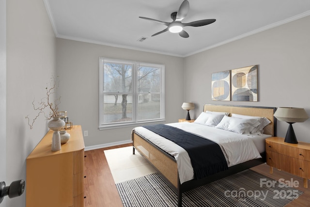 bedroom with ceiling fan, visible vents, baseboards, light wood-style floors, and crown molding