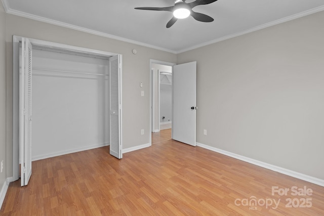 unfurnished bedroom featuring crown molding, a closet, baseboards, and light wood-style floors