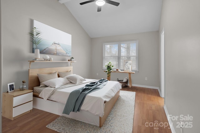 bedroom featuring lofted ceiling, ceiling fan, wood finished floors, and baseboards