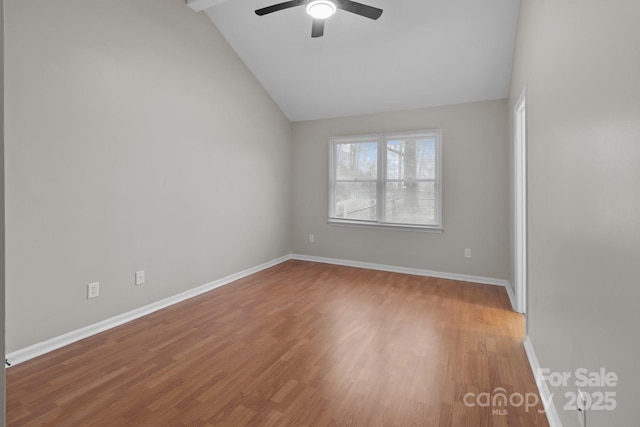 empty room with ceiling fan, vaulted ceiling, baseboards, and wood finished floors