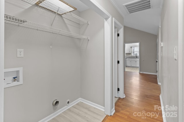 laundry area with laundry area, washer hookup, wood finished floors, visible vents, and baseboards