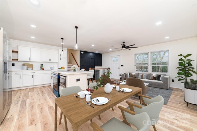 dining room with recessed lighting, stairway, and light wood finished floors