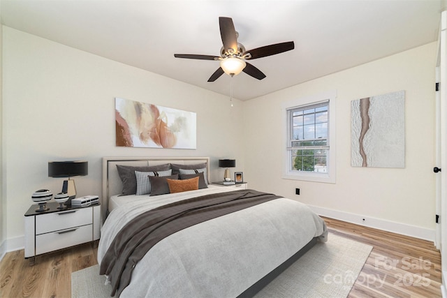 bedroom with ceiling fan, wood finished floors, and baseboards